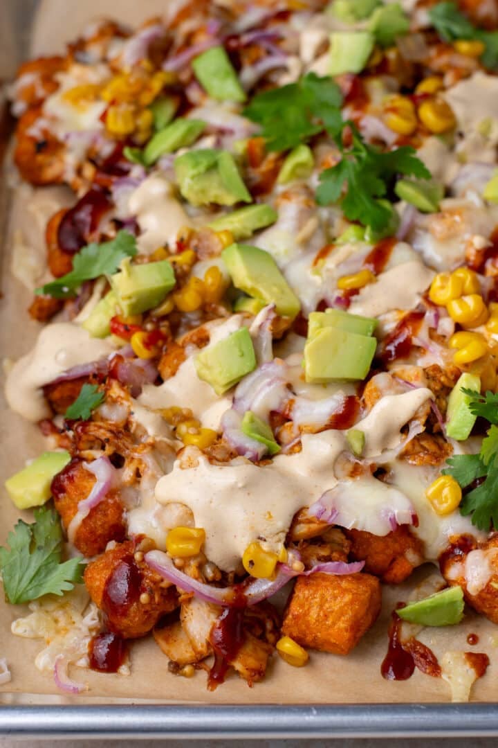 sweet potato tater tot nachos topped with BBQ chicken, bbq sauce, monterey jack cheese, avocado, corn and cilantro