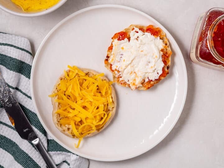 english muffin with sharp cheddar on one half and pepperjelly and cream cheese on the other half