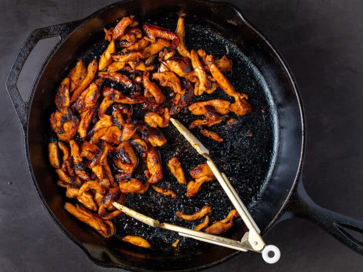 charred and carmelized chicken in a cast iron skillet