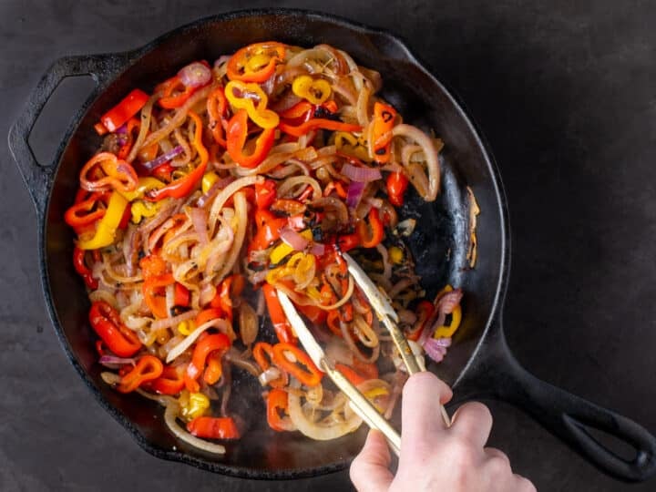 sautéed peppers and onions in a cast iron skillet