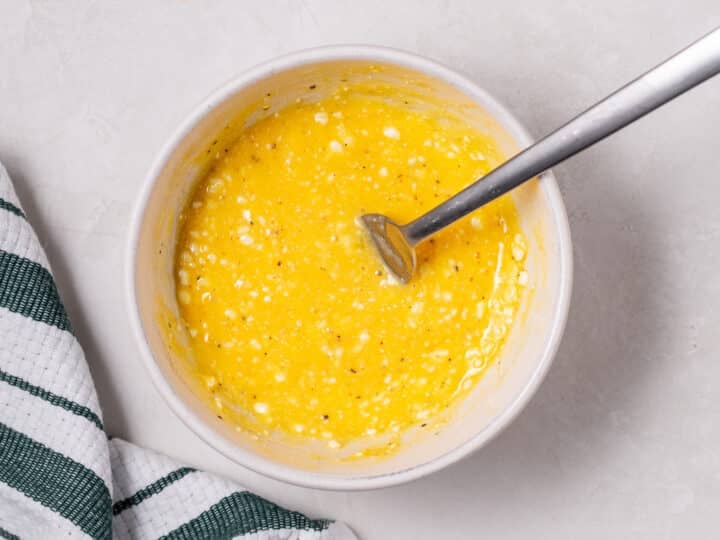 fork whisking together egg and cottage cheese in a bowl
