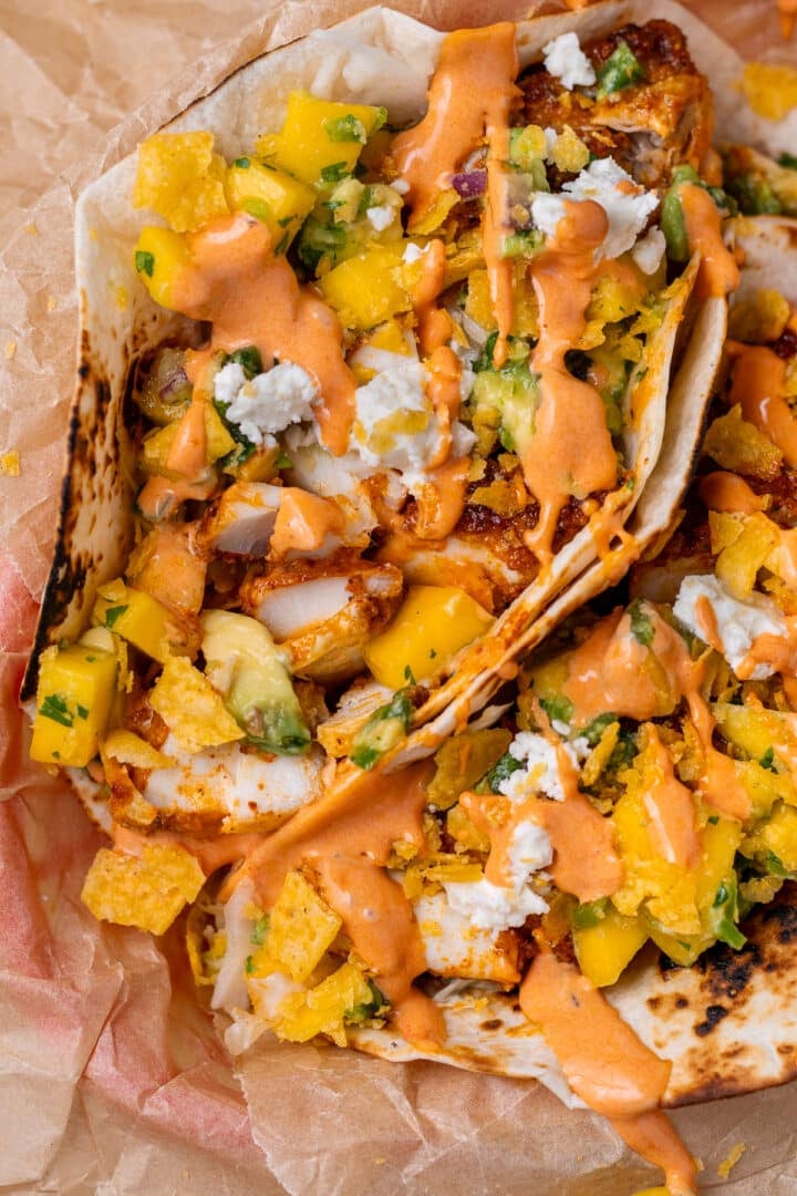 overhead view of two air fryer fish tacos drizzled with creamy chipotle sauce