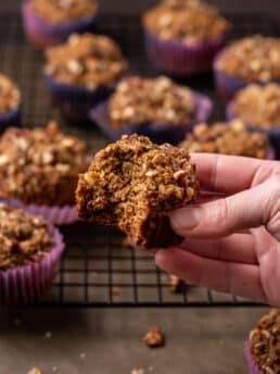 hand holding a wonderfully wholesome date muffin with a bite taken out