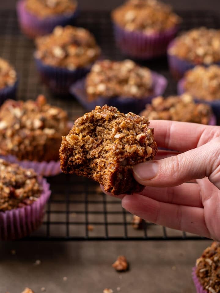 hand holding a muffin with a bite taken out