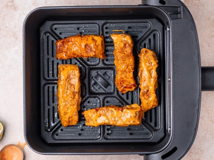 marinated fish in an air fryer basket