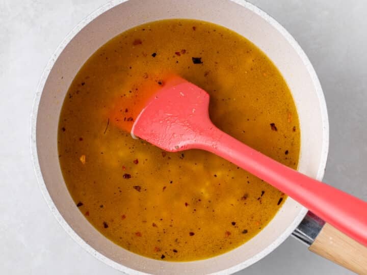 Vegetable broth added to toasted pearl couscous in skillet for couscous pilaf