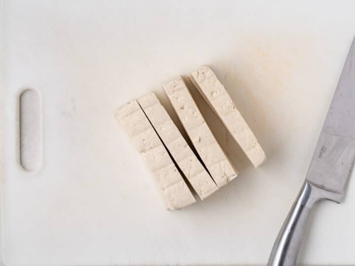 extra-firm tofu sliced into slabs on a cutting board for harissa tofu