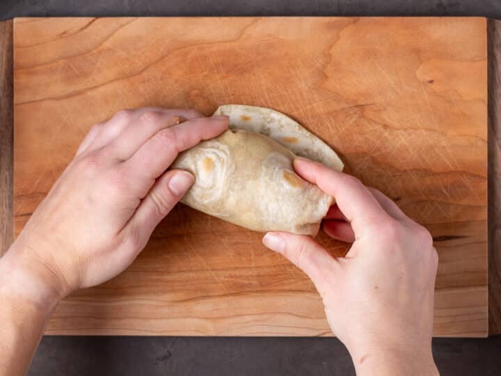 hands rolling a burrito