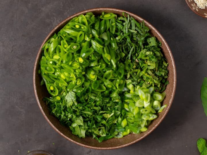 large brown bowl with snap peas and fresh herbs