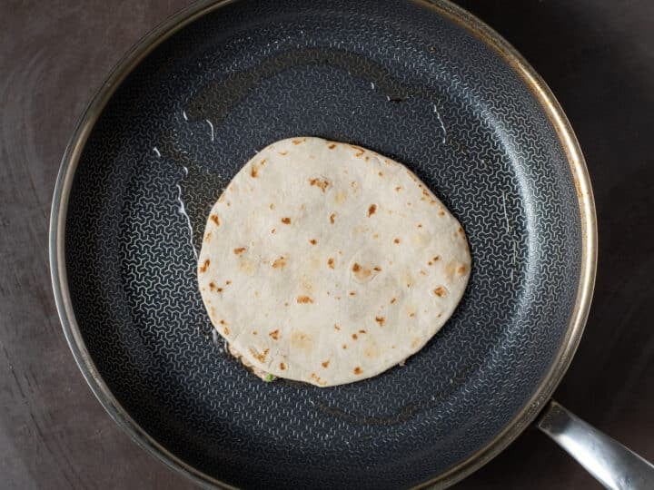 large black skillet with ahi tuna taco face down in a bit of oil