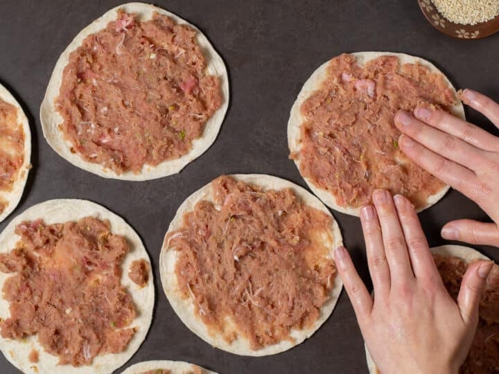 hands smashing ahi tuna mixture onto small flour tortillas