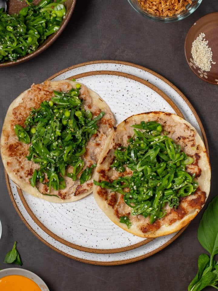 two tacos with a ahi tuna layer and a bright green fresh snap pea and herb salad inside