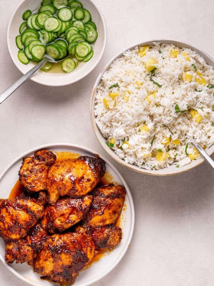 Cooked honey lime chicken thighs served with pineapple coconut rice and pickled cucumbers