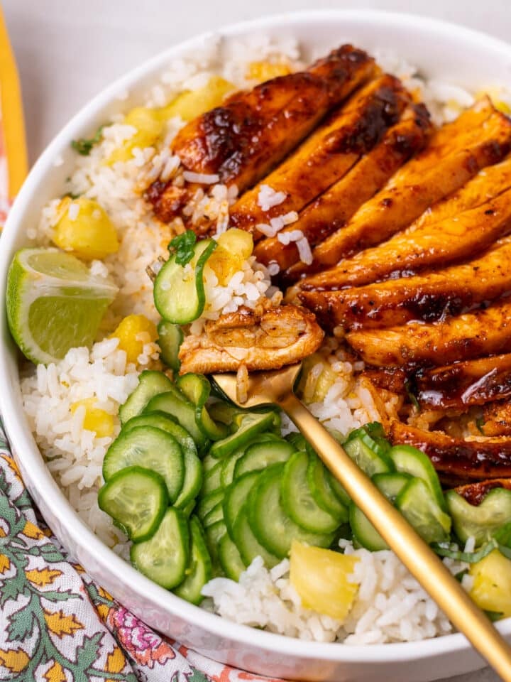 gold fork with a bite of chicken, cucumber and pineapple coconut rice