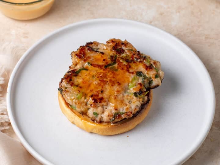 cooked chicken patty on a bun brushed with sweet chili sauce