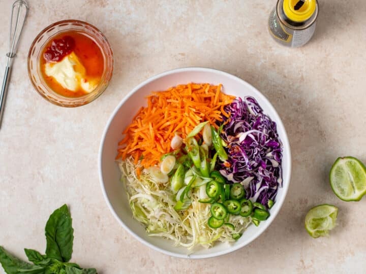 shredded cabbage, carrots, green onions and jalapeños in a bowl before mixing