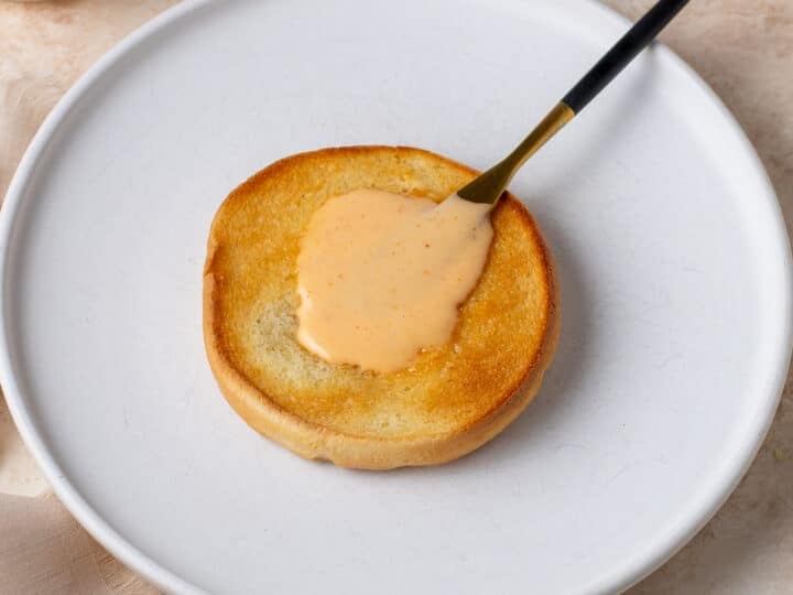 toasted bun with creamy bang bang sauce spread on top