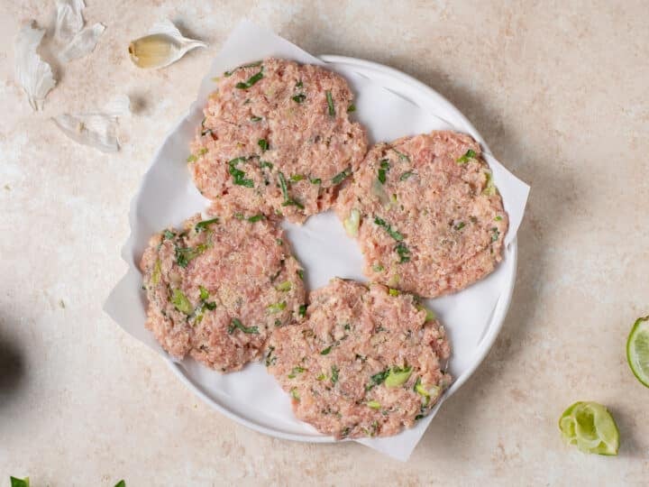 uncooked chicken patties shaped and placed on parchment paper