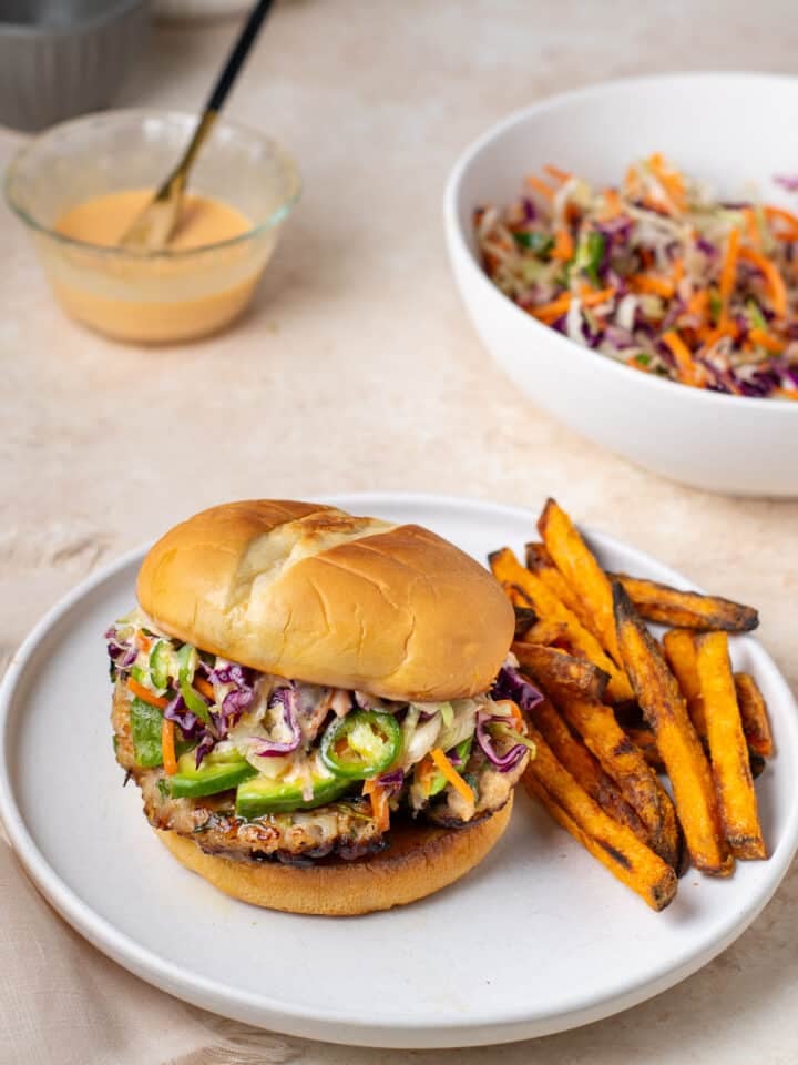 sweet chili ground chicken burger with avocado slices, sesame slaw and sweet potato fries