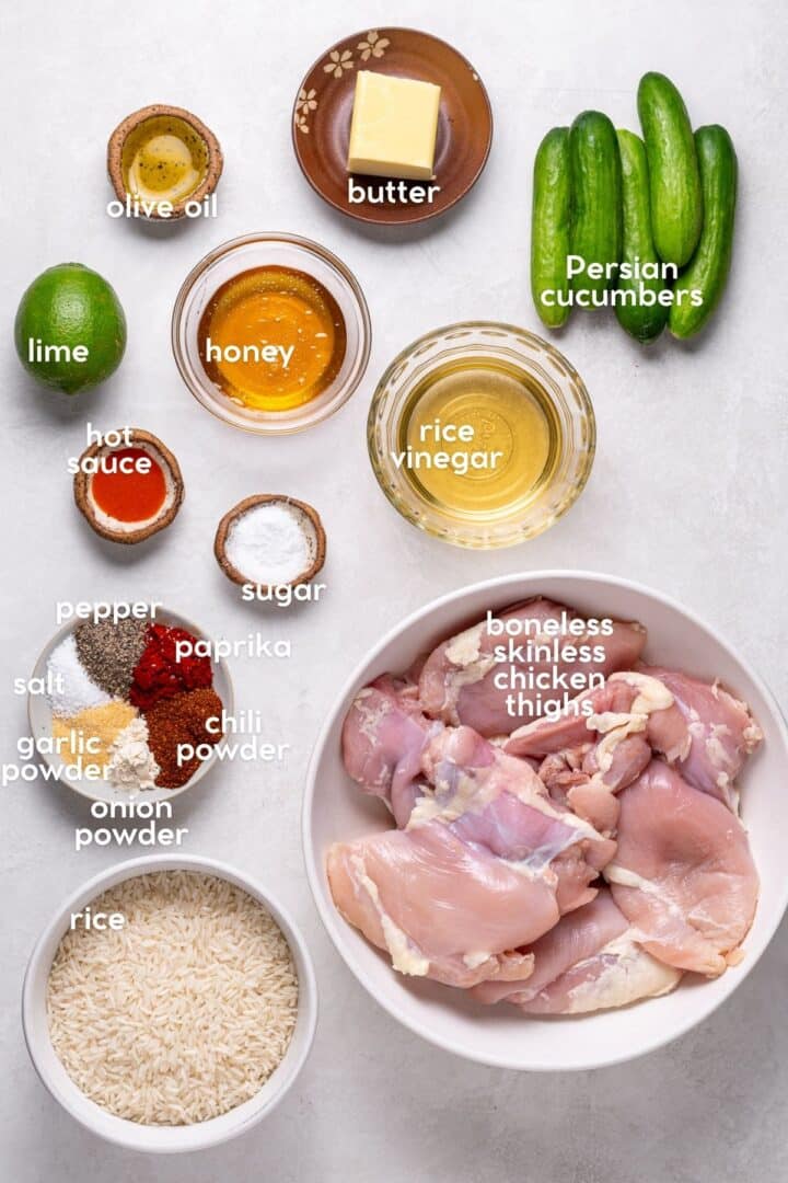Ingredients for chili lime chicken thighs including lime, honey, butter, hot sauce, spices, rice vinegar, and Persian cucumbers