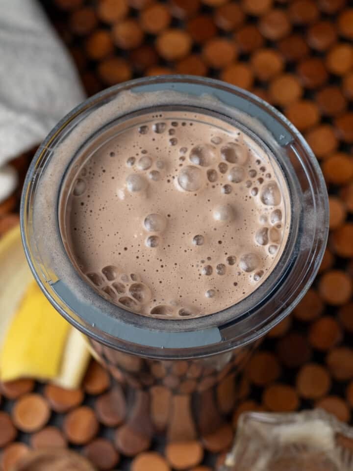 Blended iced protein coffee in blender cup with creamy smooth texture