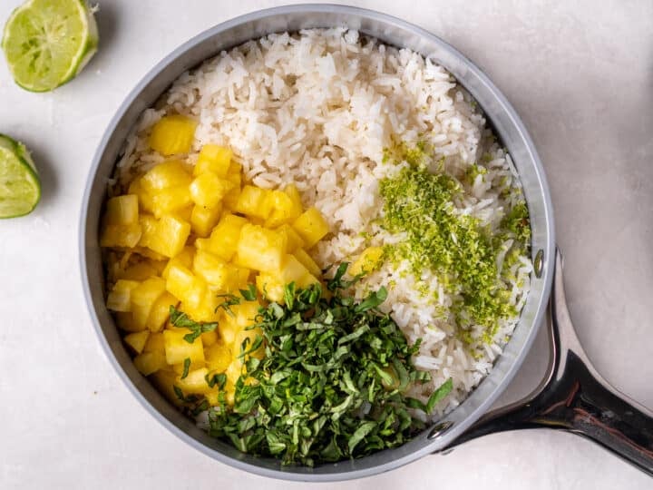 Cooked coconut rice with diced pineapple, Thai basil, and lime zest added before mixing