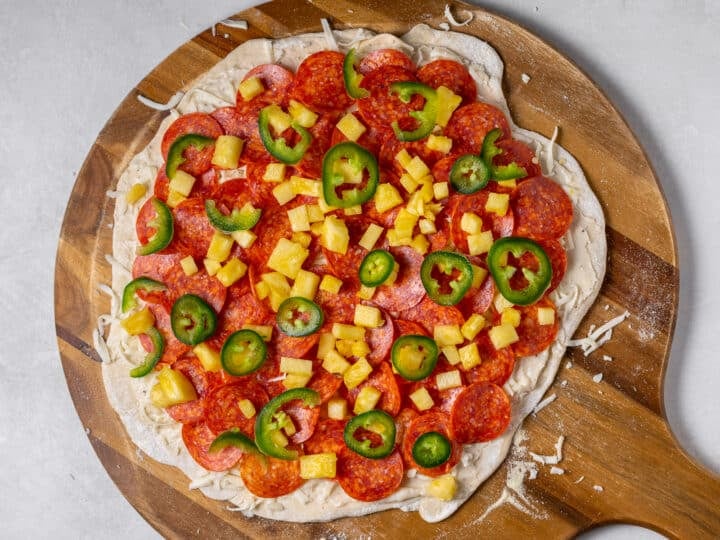 Diced pineapple and sliced jalapeños added over pepperoni on pizza before baking