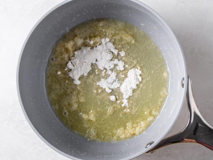 Flour added to melted butter and garlic in saucepan to make a roux
