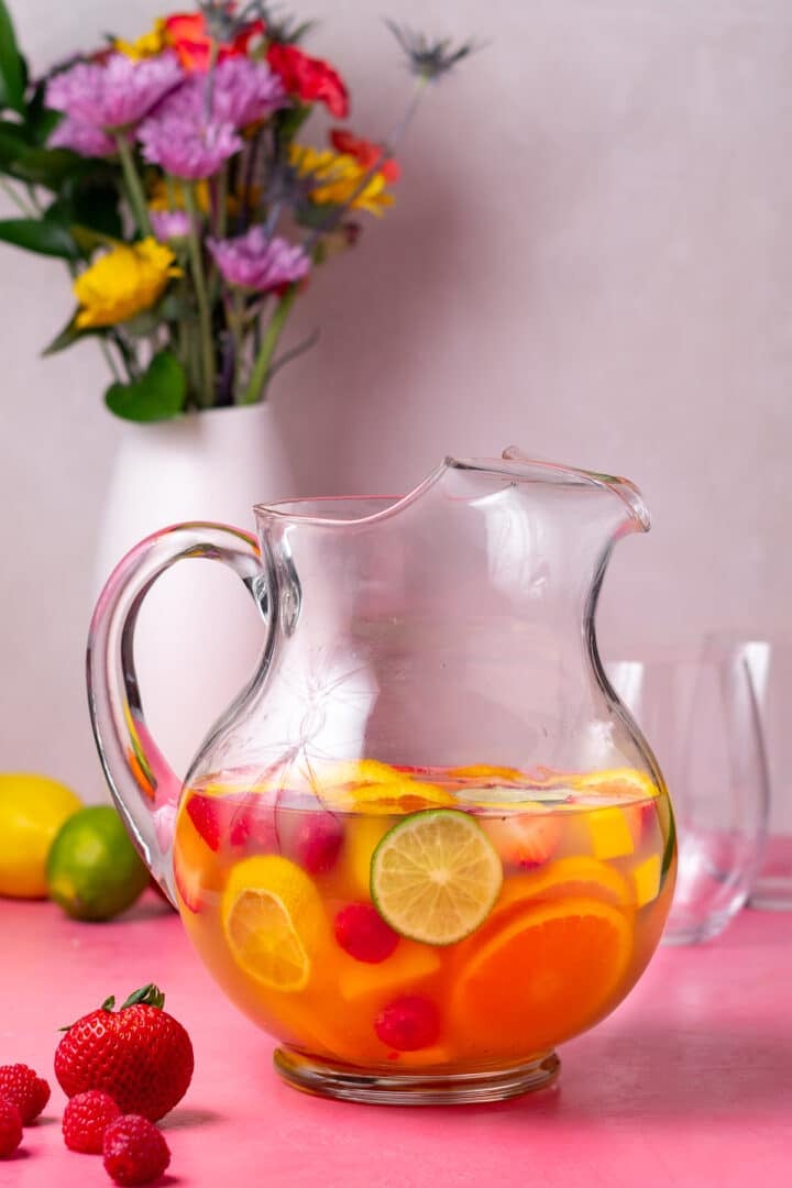 pitcher of refreshing springtime sangria with fresh fruit and raspberries
