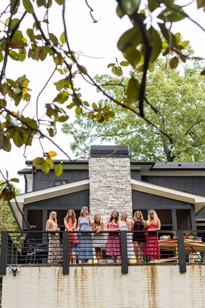 seven food bloggers standing on a balcony and smiling
