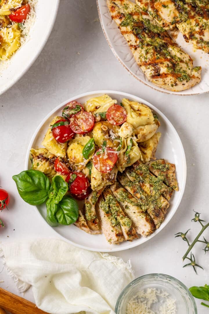 overhead view of tortellini caprese pasta salad with pesto chicken breast