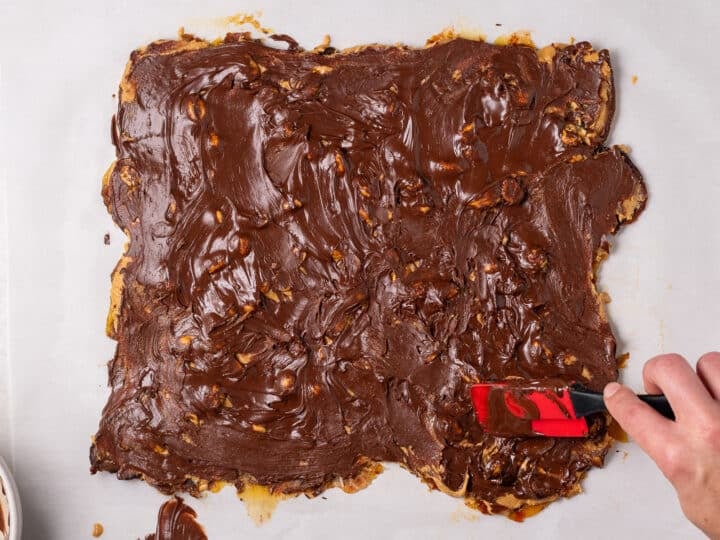 Melted chocolate spread across the top of the peanut butter date bark layer