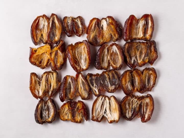 Pitted dates arranged in rows on parchment paper