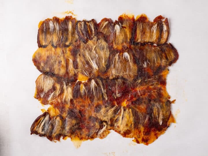 Flattened dates pressed together into one even layer on parchment paper