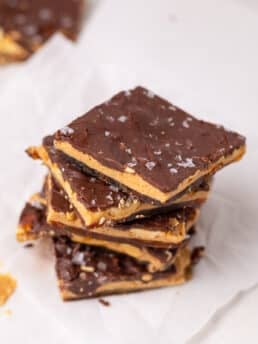 Stack of chocolate peanut butter date bark pieces showing layers of dates, peanut butter, peanuts, and chocolate