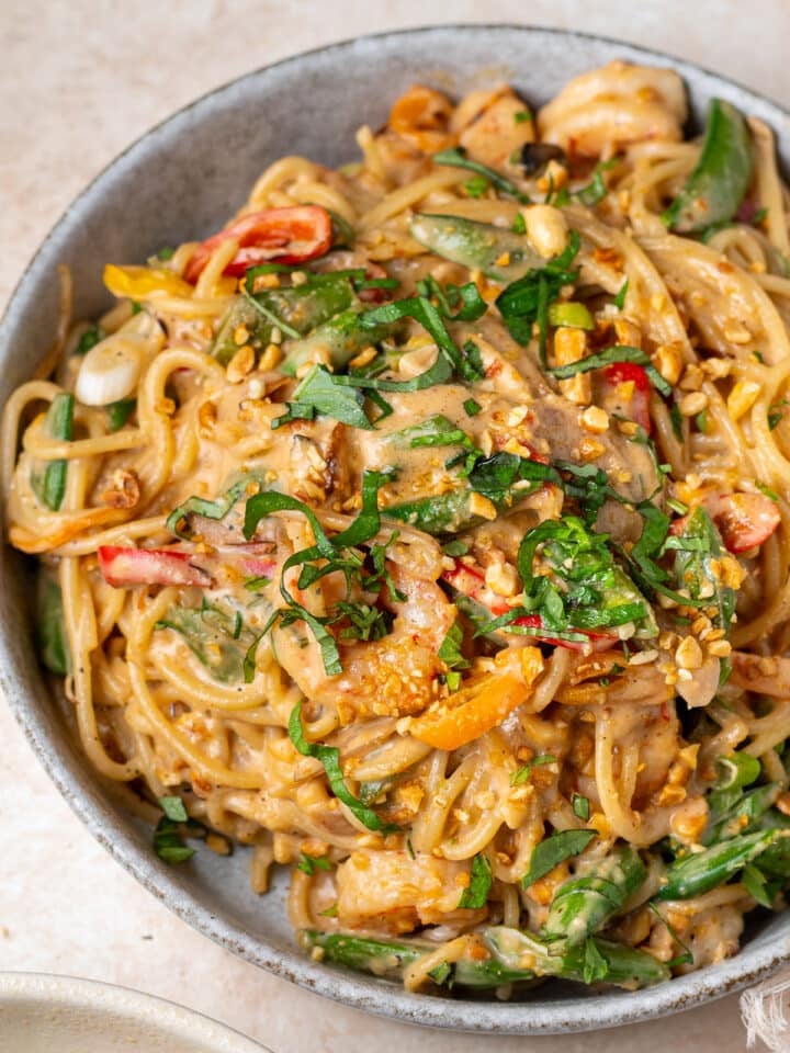 Large bowl of thai peanut noodles with shrimp, spaghetti noodles, and creamy peanut sauce