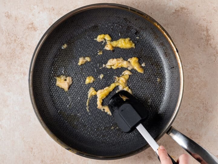 Garlic and ginger sautéing in a skillet for shrimp peanut sauce