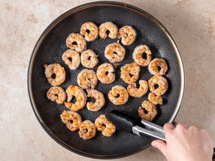 Seared shrimp cooking in a skillet for thai peanut noodles with shrimp