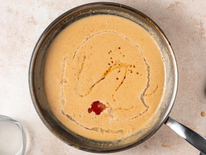 Adding sriracha, lime juice, and fish sauce to peanut sauce