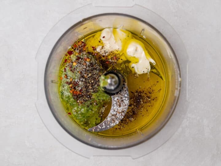pesto vinaigrette ingredients unmixed in a food processor