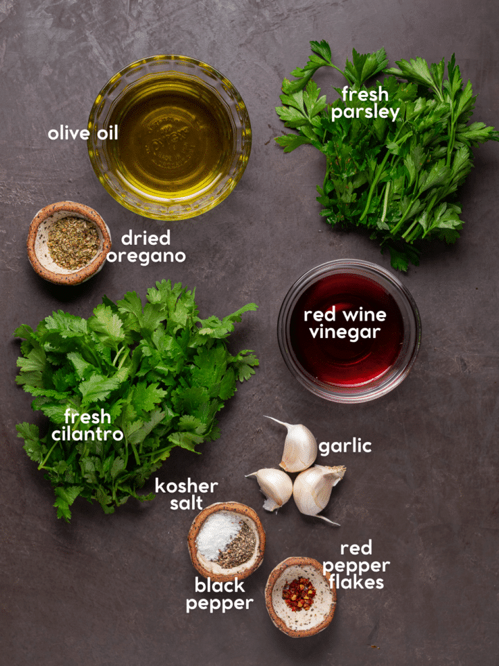 picture of the ingredients needed to make cilantro chimichurri - red wine vinegar, olive oil, cilantro, parsley, oregano, red pepper flakes, garlic, salt, pepper