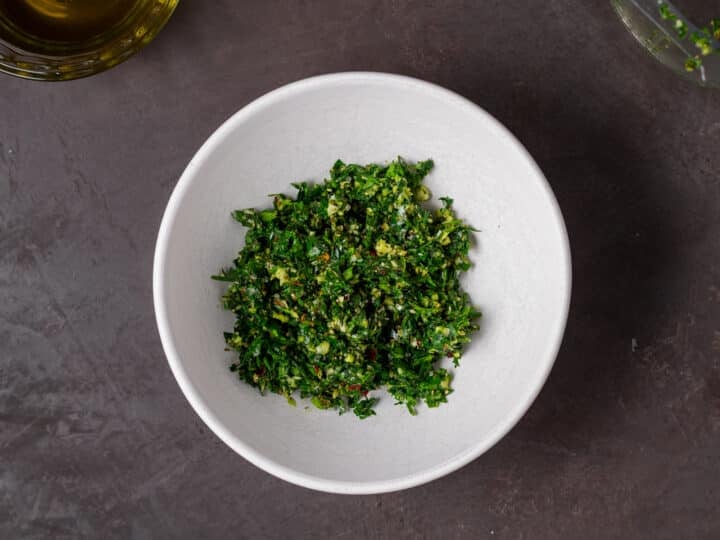 finely chopped herbs and garlic in a small white bowl