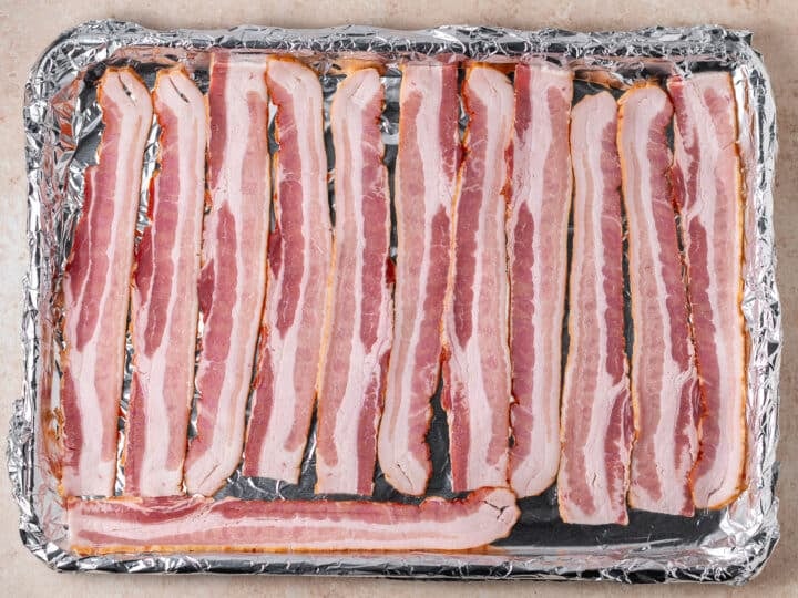 sheet pan lined with foil with raw bacon