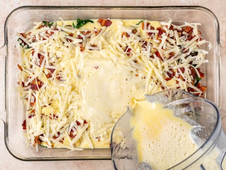pouring egg mixture into the bacon, veggies and cheese to make high protein egg bake