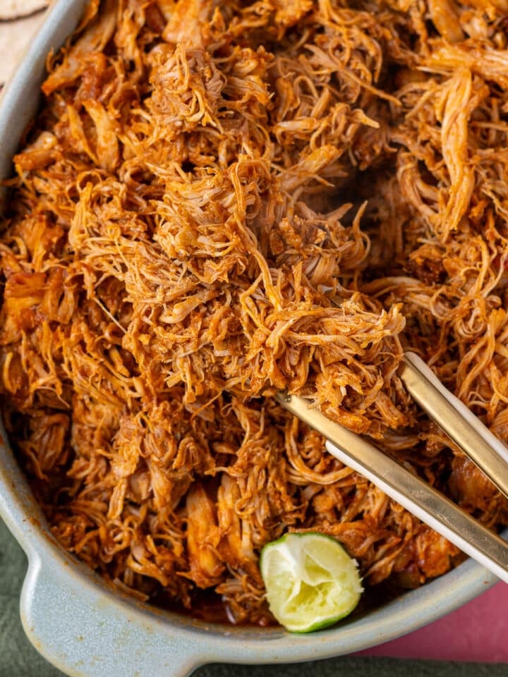 Close-up of juicy shredded chicken coated in smoky chipotle-spiced sauce.