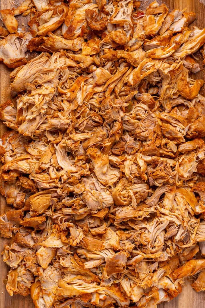 Shredded chicken spread onto a baking sheet.