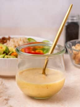 small jar of miso vinaigrette dressing with a gold spoon