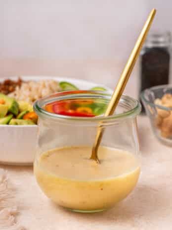 small jar of miso vinaigrette dressing with a gold spoon