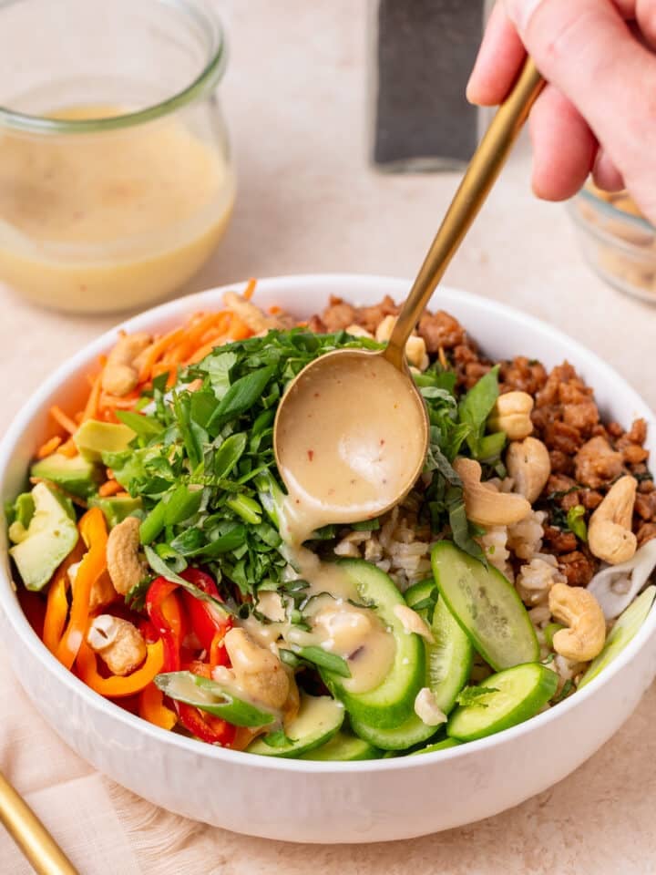 Power bowl with rice, garlic ginger chicken, avocado, peppers, cucumbers, herbs and cashews topped with creamy dressing.