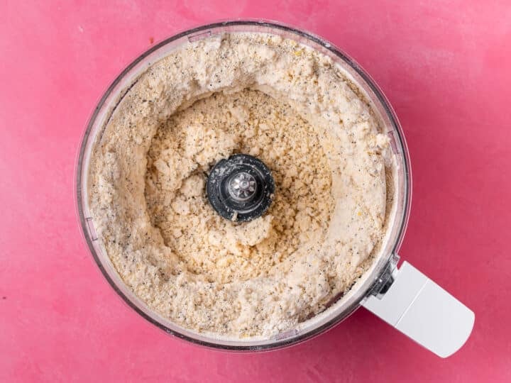 Sandy flour and butter mixture with lemon zest and poppy seeds in a food processor.